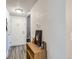Hallway features white door, wood-look flooring, a small bookshelf with decorations, and textured walls at 940 S Peoria St, Aurora, CO 80012