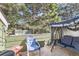 Relaxing outdoor patio space with a blue chair, patio furniture, and a view of mature trees at 940 S Peoria St, Aurora, CO 80012