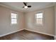 Bright bedroom featuring wood floors, ceiling fan, and two large windows at 4441 Elm Ct, Denver, CO 80211