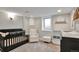 Charming Bedroom with a black crib, comfortable chair and storage at 4441 Elm Ct, Denver, CO 80211