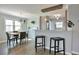 Sunlit dining area and kitchen with a breakfast bar and modern pendant lighting at 4441 Elm Ct, Denver, CO 80211