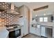 Modern kitchen features stainless steel appliances and exposed brick accent wall at 4441 Elm Ct, Denver, CO 80211