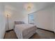 A serene bedroom showcases a plush bed, complemented by soft lighting and a window offering a tranquil view at 6047 N Nepal Ct, Aurora, CO 80019
