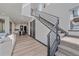 Bright entryway with staircase, modern railing, hardwood floors, and open layout at 6047 N Nepal Ct, Aurora, CO 80019