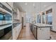 Modern kitchen featuring an island with bar stools, hardwood floors, and modern appliances at 6047 N Nepal Ct, Aurora, CO 80019