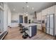 Spacious kitchen with an island, modern lighting, and stainless steel appliances at 6047 N Nepal Ct, Aurora, CO 80019
