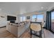 The living room features a comfortable seating area, television, and access to the balcony with exterior views at 6047 N Nepal Ct, Aurora, CO 80019