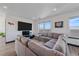 Comfortable living room featuring a plush sectional sofa, entertainment center, and natural light at 6047 N Nepal Ct, Aurora, CO 80019