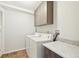 Practical laundry room with side-by-side washer and dryer, storage cabinets, and tiled countertop at 2905 E Yarrow Cir, Superior, CO 80027