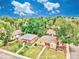 Aerial view of a neighborhood showcasing well-maintained homes, mature trees, and lush green lawns under a bright blue sky at 1600 Xanthia St, Denver, CO 80220
