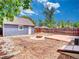 Backyard featuring a fire pit, concrete patio, a detached garage and surrounded by a wooden fence at 1600 Xanthia St, Denver, CO 80220