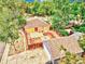 Aerial view of a backyard with a fire pit and detached garage, all surrounded by a wood fence and mature trees at 1600 Xanthia St, Denver, CO 80220
