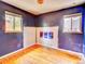 Bedroom with hardwood floors, two windows, and a unique wall mural at 1600 Xanthia St, Denver, CO 80220