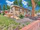 Brick home showcasing meticulous landscaping, stone accents, and lush greenery at 1600 Xanthia St, Denver, CO 80220