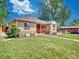 Quaint single-story brick home featuring well-maintained front lawn and cozy screened-in porch at 1600 Xanthia St, Denver, CO 80220