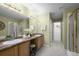 Bathroom with dual sinks, large mirror, walk-in shower, and a separate toilet and closet room at 7700 W Grant Ranch Blvd # 7C, Littleton, CO 80123