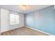 Bright bedroom with a large window, neutral carpet, and light blue accent wall at 12861 Royal Ct, Broomfield, CO 80020