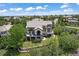 Aerial view of landscaped home on a large lot in a desirable neighborhood with lush trees and beautiful sky at 6299 Ellingwood Point Pl, Castle Rock, CO 80108