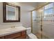 Bright bathroom featuring white countertops, a framed mirror, and a glass-enclosed shower at 6299 Ellingwood Point Pl, Castle Rock, CO 80108