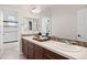 Bright bathroom featuring white tile countertops, a mirrored wall, and dual sinks at 6299 Ellingwood Point Pl, Castle Rock, CO 80108