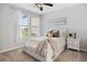 Cozy bedroom with a white bed frame, carpet flooring, and bright natural lighting at 6299 Ellingwood Point Pl, Castle Rock, CO 80108