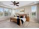 Bright bedroom with tray ceilings, carpet flooring, and large windows at 6299 Ellingwood Point Pl, Castle Rock, CO 80108