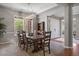 Formal dining room featuring a large wooden table, elegant lighting, and a view of the front yard at 6299 Ellingwood Point Pl, Castle Rock, CO 80108