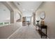 Bright hallway with carpet flooring, a console table, and a view of the second floor at 6299 Ellingwood Point Pl, Castle Rock, CO 80108