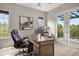 Bright home office with a large desk, comfortable chair, and access to a private balcony at 6299 Ellingwood Point Pl, Castle Rock, CO 80108