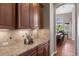 Elegant kitchen counter with wooden cabinets and granite countertops and sight lines into the dining room at 6299 Ellingwood Point Pl, Castle Rock, CO 80108