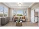 Bright living room with carpet flooring, large windows, and a gray couch at 6299 Ellingwood Point Pl, Castle Rock, CO 80108