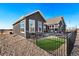 Fenced backyard featuring green lawn, modern home exterior, and rock landscaping at 359 Josef Cir, Fort Lupton, CO 80621