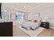 Spacious bedroom featuring a tray ceiling, a sitting area, and light wood flooring at 359 Josef Cir, Fort Lupton, CO 80621