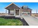 Charming home with dark gray stucco, stone accents, and landscaped front yard at 359 Josef Cir, Fort Lupton, CO 80621
