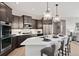 Stylish kitchen with dark cabinetry, stainless steel appliances, and a large island with pendant lighting at 359 Josef Cir, Fort Lupton, CO 80621