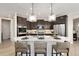 Modern kitchen featuring dark cabinets, stainless steel appliances, and a large island with quartz countertops at 359 Josef Cir, Fort Lupton, CO 80621