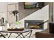 Living room with modern fireplace, tile surround, large painting and sun-lit seating area at 359 Josef Cir, Fort Lupton, CO 80621