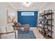 Home office featuring a blue accent wall, wood desk, and built-in shelving with natural light at 359 Josef Cir, Fort Lupton, CO 80621