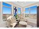 Cozy sitting area with two chairs, footstool, and lots of light from many windows at 359 Josef Cir, Fort Lupton, CO 80621