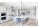 Bright kitchen boasts stainless steel appliances, large island with bar seating and modern lighting at 27500 E Lakeview Dr, Aurora, CO 80016