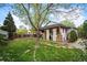 Expansive backyard with a covered patio, a built-in outdoor kitchen, and lush green lawn at 6480 Moss Cir, Arvada, CO 80007