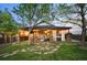 Inviting covered patio with outdoor kitchen, seating area, hot tub, and lush landscaping, ideal for relaxing and entertaining at 6480 Moss Cir, Arvada, CO 80007