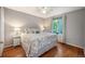 Bedroom with hardwood floors, a large window, and closet at 6480 Moss Cir, Arvada, CO 80007