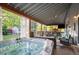 Spacious covered patio featuring jacuzzi, outdoor seating, tv, and grilling area at 6480 Moss Cir, Arvada, CO 80007