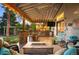 Relaxing covered patio features outdoor kitchen, fire pit, ceiling fan and comfortable seating at 6480 Moss Cir, Arvada, CO 80007