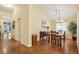 Open dining room with hardwood floors, chandelier and adjacent room at 6480 Moss Cir, Arvada, CO 80007