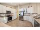 Spacious kitchen featuring stainless steel appliances and granite countertops, perfect for culinary enthusiasts and entertaining guests at 6480 Moss Cir, Arvada, CO 80007