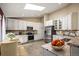 Bright eat-in kitchen featuring skylight, granite countertops, stainless steel appliances, and white cabinetry at 6480 Moss Cir, Arvada, CO 80007