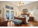 Well lit main bedroom boasts vaulted ceiling, French doors, hardwood floors, and stylish decor at 6480 Moss Cir, Arvada, CO 80007
