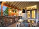 Stylish outdoor kitchen with grill, mini fridge, unique decorative backsplash and barrel table at 6480 Moss Cir, Arvada, CO 80007
